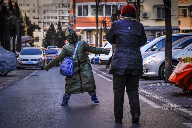 Một người đi đường mặc áo như chiếc chăn để giữ ấm.