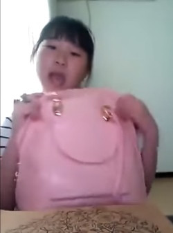 Nữ sinh nhỏ tuổi khoe chiếc túi xách mà mẹ cô mua từ Hàn Quốc.