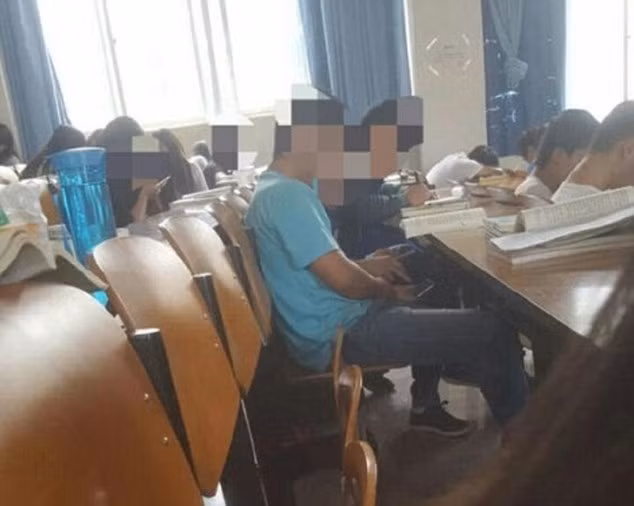 Trong bức ảnh do một sinh viên khác ngồi ngay sau nạn nhân chụp được, thủ phạm giả vờ chú ý nghe giảng bài nhưng tay của cậu ta cầm điện thoại để sau lưng và chụp ảnh "vùng kín" của những bạn nữ ngồi ở hàng ghế phía sau.