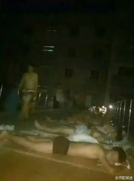 Hành lang nối giữa hai tòa nhà ký túc xá của Học viện Khoa học và Công nghệ Lạc Dương la liệt nam sinh viên nằm hóng mát. Phần lớn các sinh viên cởi trần và chỉ mặc quần soóc ngắn trong khi ngủ ngoài trời.