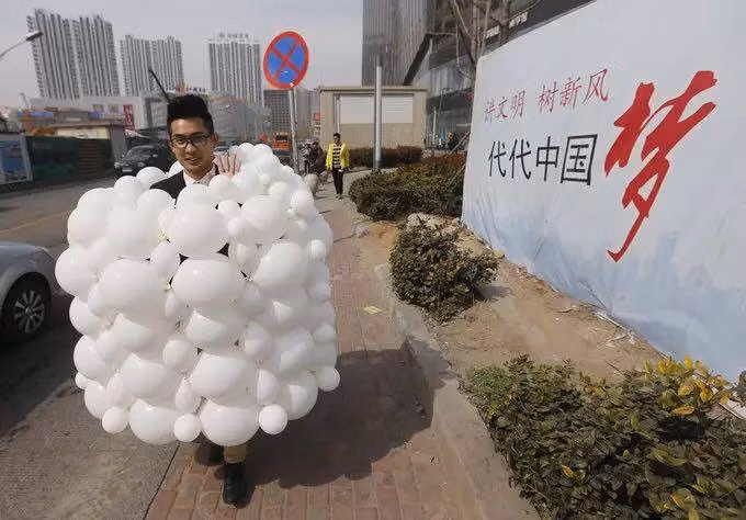 Chàng trai trẻ tỏ ra rất ưng ý với chiếc váy cưới từ bóng bay do danh tự thiết kế để dành tặng vợ chưa cưới.