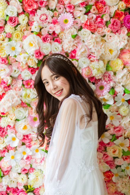 Cô giáo tương lai trông như nàng tiểu thư đài các đứng cạnh những bông hoa rực rỡ sắc màu.