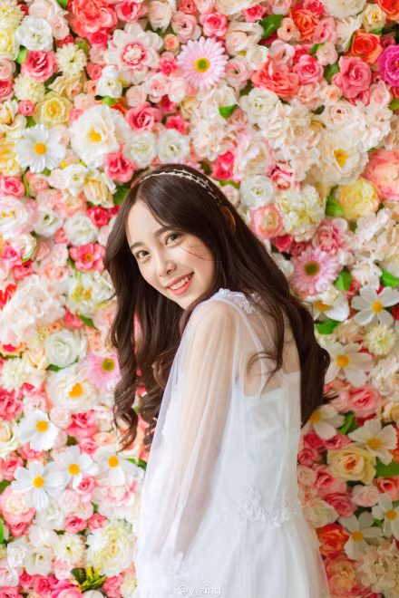 Cô giáo tương lai trông như nàng tiểu thư đài các đứng cạnh những bông hoa rực rỡ sắc màu.