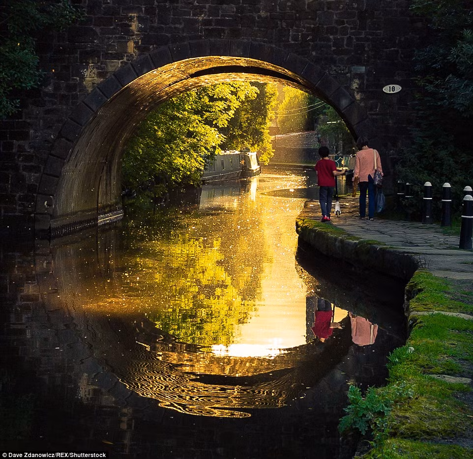 Du khách đi dạo dọc dòng kênh phẳng lặng dưới cây cầu Hebden ở Yorkshire, Vương quốc Anh. (Nguồn: Daily Mail)