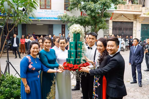 Nhà chồng của Mai Ngọc xuất hiện lúc 13 giờ chiều. Tất cả các thành viên của gia đình đều ăn mặc rất sang trọng, tươi vui và cùng chung niềm vui với cặp trai tài gái sắc.