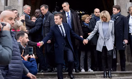 Trong bức ảnh đầu tiên, ông Emmanuel Macron dang tay theo hai hướng ngược nhau, một tay về phía người ủng hộ còn tay kia nắm chặt tay vợ mình (trong ảnh), chuyên gia Darren đã đưa ra nhận xét cá nhân về tính cách của họ.