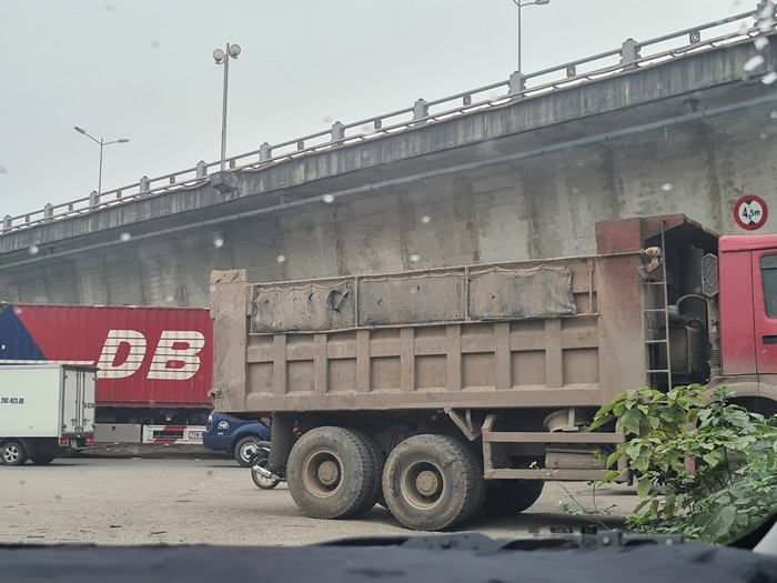 Cát được thuyền vận chuyển, sau đó tập kết thành đống cao vút ở bờ sông Hồng, thuộc khu vực Cảng Thanh Trì, rồi những chiếc xe tải đến vận chuyển.