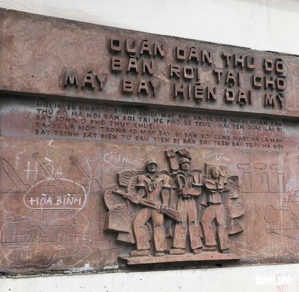 Tại một mặt của tòa nhà đối diện Nguyễn Thái Học là bức phù điêu khắc lại hình ảnh đắp nổi hình ảnh dân quân tự vệ bảo vệ Hà Nội trong kháng chiến chống Mỹ. Đây từng là vị trí dân quân Hà Nội bắn rơi máy bay Mỹ vào đúng ngày 19-5-1967. (Ảnh: Tuổi Trẻ).