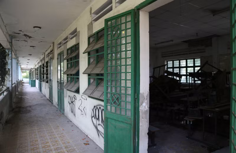 Dãy hành lang trường tiểu học Phú Định bám đầy bụi mốc, bàn ghế ngổn ngang tạo nên không gian u ám bao trùm cả ngôi trường mà trước kia luôn rộn ràng tiếng trẻ thơ.