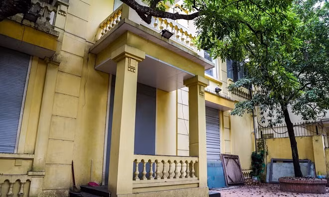 Bề ngoài biệt thự có thiết kế đơn giản, sơn đã ngả màu, cửa chính và cửa sổ là loại cửa kéo, nhôm kính. Ảnh: Nhà Đầu tư. 