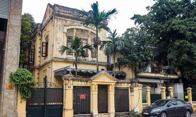 Biệt thự 2 tầng trông khá cũ kỹ, trong khuôn viên là hàng cau thẳng tắp hiếm có trên phố này. Ảnh: Nhà Đầu tư. 