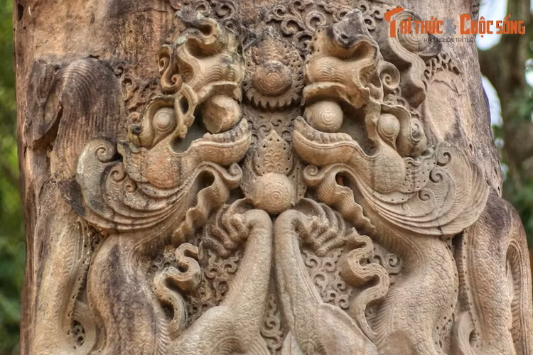 Phần đỉnh cột được chạm nổi đôi rồng theo đồ án “lưỡng long hiến châu”. Đầu rồng nhô cao chầu nhau, miệng ngậm ngọc, được chạm khắc với những hoa văn vô cùng tinh xảo. Chân trước cặp rồng chụm lại dâng một viên ngọc cùng cỡ với viên ngọc ngậm ở miệng.