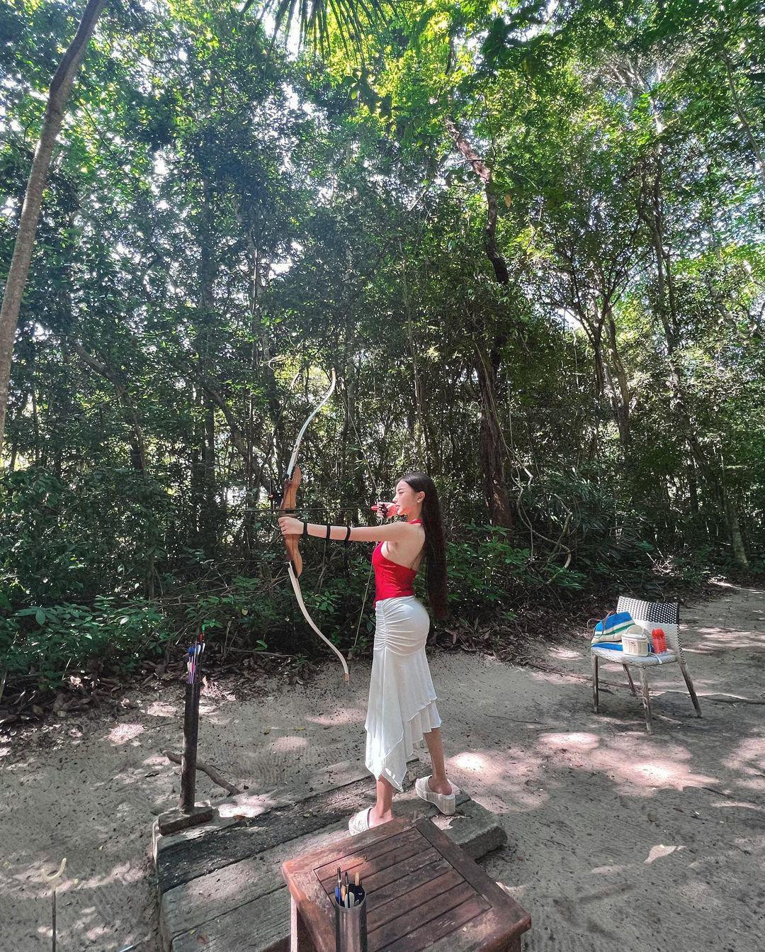 Theo đó, người đẹp diện áo thun đỏ, cắt khoét hở lưng, xẻ sâu, kết hợp cùng chân váy dây rút, ôm sát, mỏng manh tôn số đo vòng 3.