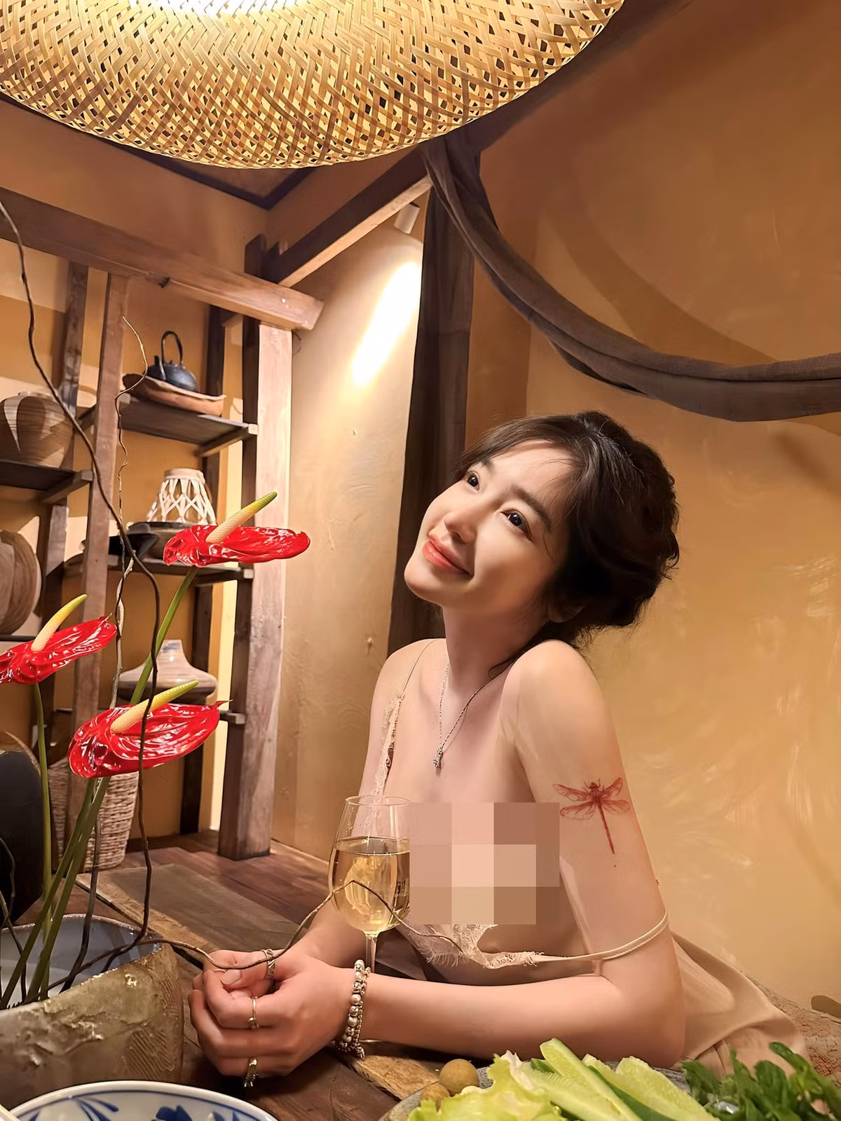 Elly Trần còn sở hữu hình xăm hình chú chuồn chuồn. Màu mực đỏ càng nổi và thu hút hơn trên nước da trắng mịn màng của mẹ hai con.