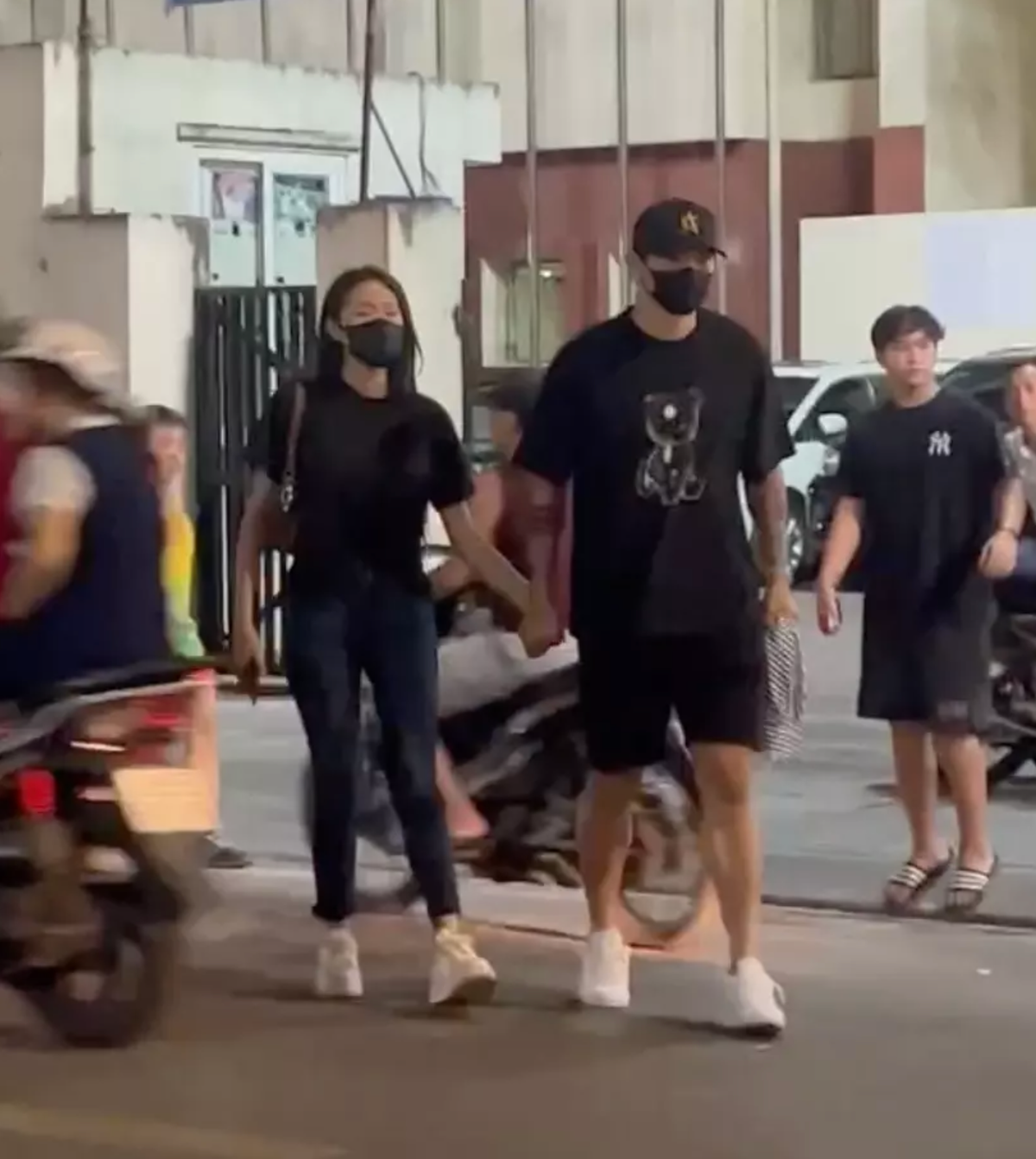 Nam hậu vệ và vợ sắp cưới cùng diện đồ đôi màu đen, giày trắng nổi bật. Khi qua đường, Văn Hậu nắm chặt tay vợ, anh đi trước để dẫn đường cho Hải My.