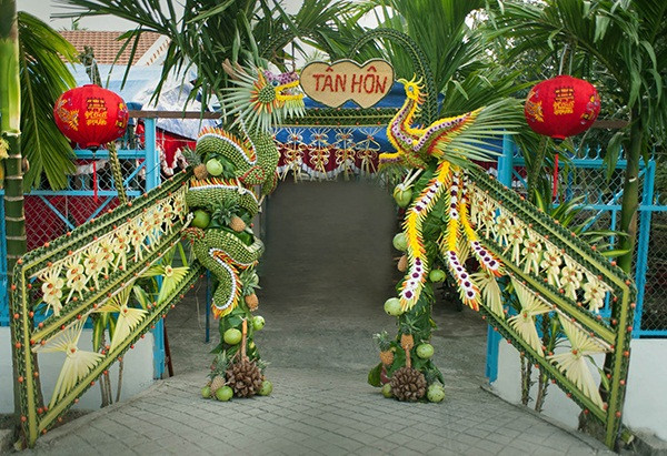 Thay vì kết cổng cưới bằng hoa hay vải lụa, bóng bay như các tỉnh thành miền Bắc. Ở miền Tây họ lại chọn chất liệu là lá dừa, lá cọ để tạo thành chiếc cổng cưới độc đáo, đẹp mắt và ý nghĩa.