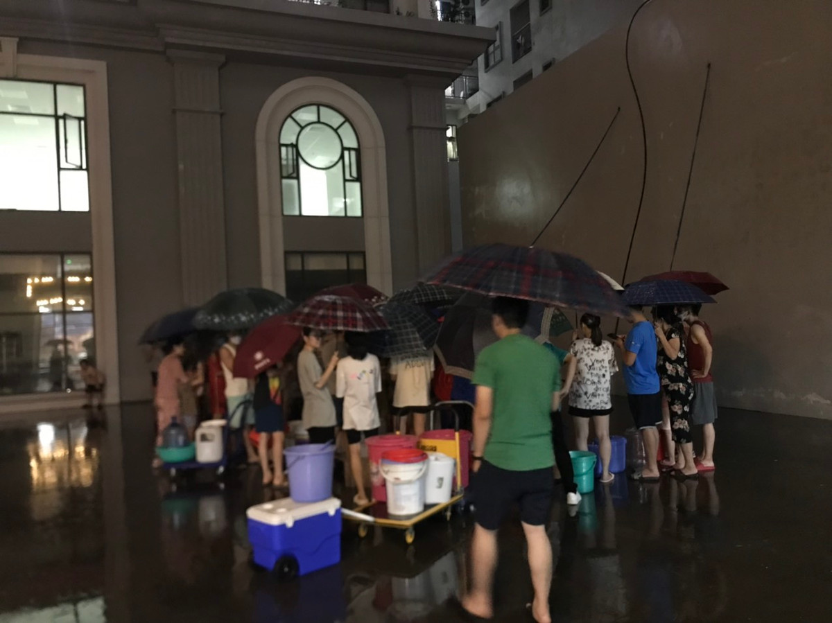 Hơn 23h đêm 23/9, rất đông cư dân sống tại chung cư Hateco, phường Phương Canh, Nam Từ Liêm, Hà Nội vẫn kiên trì đứng xếp hàng để chờ lấy được ít nước sạch mang lên sử dụng.