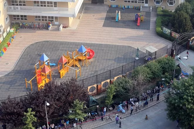 Hàng dài được xếp phía trước trường. Nhiều phụ huynh cho biết họ thậm chí đã phải huy động cả người nhà để đứng xếp hàng.