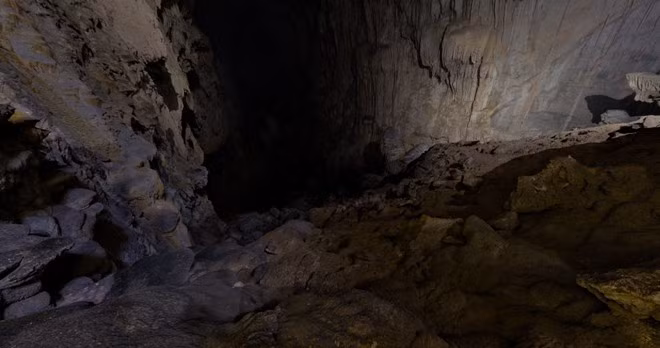 Lối vào hang Sơn Đoòng là một con dốc hẹp hun hút trong bóng tối. Việc thám hiểm hang mà không có ánh sáng nhân tạo là điều không thể.