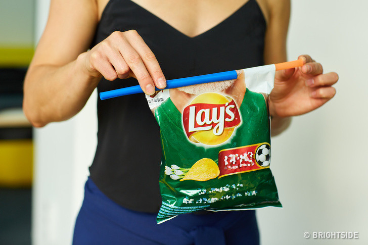 Bạn dùng 2 ống hút để tạo thành một chiếc khóa cho túi đựng snack chưa ăn hết. Trước tiên, bạn lấy một ống hút rồi cuộn vỏ túi snack thành 1 vòng bao quanh ống hút đó. Sau đấy, lấy kéo cắt ngang ống hút thứ hai rồi luồn nó phía trên chỗ cuộn ống hút đầu tiên.