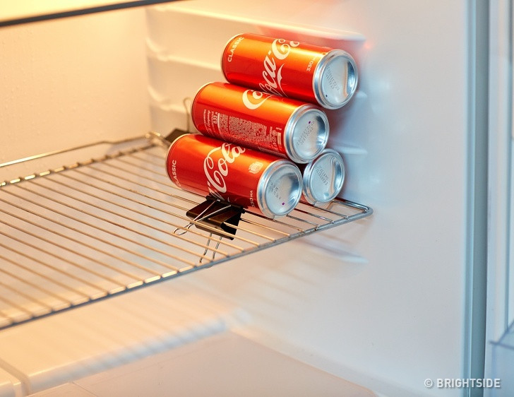 Ngăn chai hay lon bia, lon nước uống lăn trên kệ tủ lạnh. Bạn kẹp một ghim kẹp giấy như hình trên rồi sau đó xếp hình kim tự tháp các chai lọ đó trên kệ tủ lạnh.