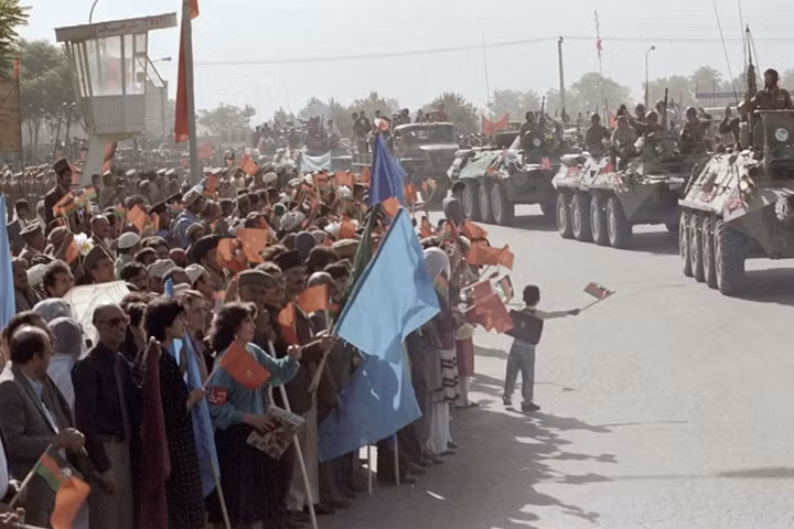 Người dân Afghanistan theo dõi và vẫy chào đoàn xe quân đội Liên Xô rút lui.