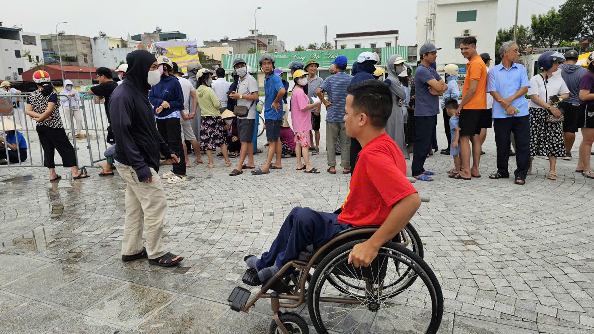 Một người đi xe lăn đến khu vực bán cá.