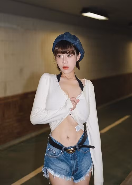 Hot girl xinh đẹp mặc quần short, vén áo khoe vòng một trên đường phố.