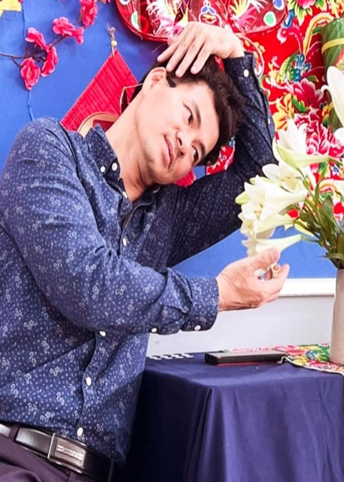 Nam diễn viên hài biểu cảm hài hước khi tạo dáng bên hoa huệ.