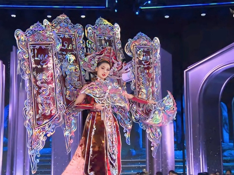 Trang phục dân tộc của Quế Anh lấy cảm hứng từ nét đẹp của nghề khảm vỏ ốc, vỏ trai... truyền thống. Trên sân khấu Miss Grand International 2024, “Khảm xà cừ" tạo nên hiệu ứng ấn tượng nhờ các chi tiết lấp lánh, màu sắc bắt mắt. Đặc biệt, hai chiếc quạt hình cánh bướm độc đáo, có thể xoay chuyển linh hoạt giúp phần trình diễn của Quế Anh thêm phần sinh động và thú vị. Ảnh: Sen Vàng.