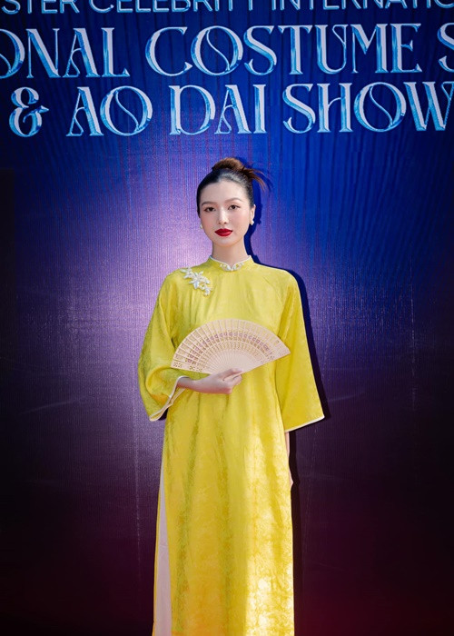 Tuệ Như dùng chiếc quạt che bụng bầu khi diện áo dài.