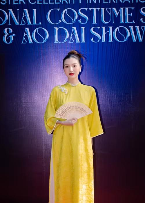 Tuệ Như dùng chiếc quạt che bụng bầu khi diện áo dài.