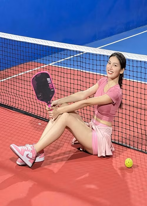 Chân dài chuộng váy áo tông hồng, trắng trên sân tập. Ảnh: FB Ngọc Thảo.