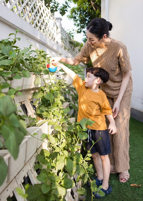 Khoảnh khắc Tú Anh cùng con trai tưới cây. Ảnh: FB Tú Anh.
