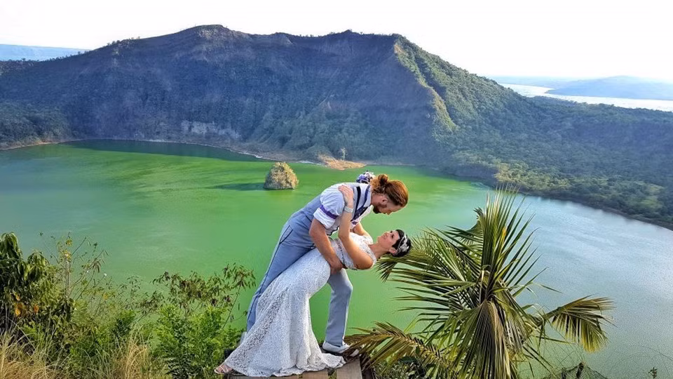 Đôi lúc họ gặp trời mưa hoặc tổ chức đám cưới sau khi vừa cãi nhau. Nhưng "mỗi đám cưới đều hoàn toàn khác biệt, giống như mỗi ngày ở bên cô ấy", chú rể thổ lộ. Trong ảnh là một điểm dừng chân khác của họ tại châu Á - núi lửa Taal ở Philippines. Ngọn núi lửa đang hoạt động này khá độc đáo nhờ có một hồ nước bao quanh, trên núi lại có một hồ khác.