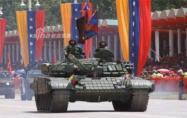Xe tăng T-72B1V của lực lượng thiết giáp Venezuela tham gia cuộc duyệt binh. Đây là phiên bản nâng cấp dành cho Venezuela của dòng tăng T-72B với giáp phản ứng nổ Kontak-1 và pháo 125mm. Nguồn ảnh: Sina.