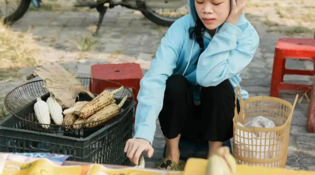 Đặc biệt thời gian qua, hiện tượng mạng này xuất hiện với hình ảnh ngồi bán ngô nướng lề đường, kiếm thêm thu nhập phụ giúp gia đình càng khiến netizen tò mò hơn về hoàn cảnh của cô.