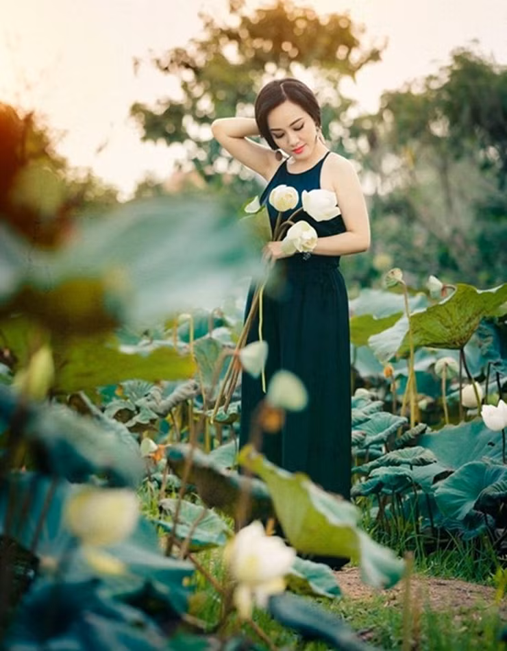 Ngoài áo yếm, cô cũng mặc áo dài tím chụp cùng sen. Hoài Anh toát lên vẻ đẹp dịu dàng, nền nã của người phụ nữ Á Đông.