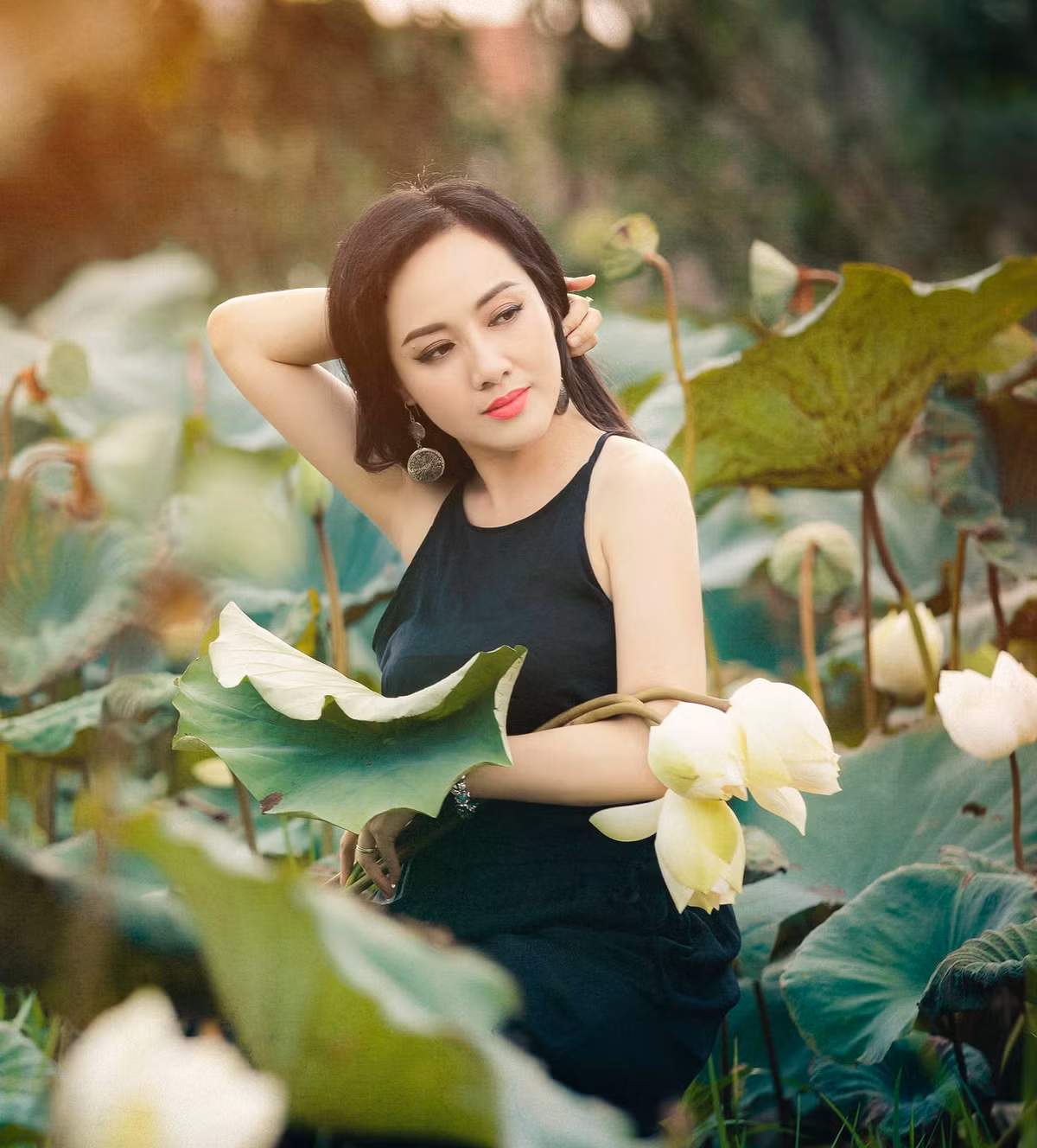 Trong bộ ảnh, BTV VTV được khen khi mặc áo yếm, đội nón lá chụp ảnh giữa đầm sen.