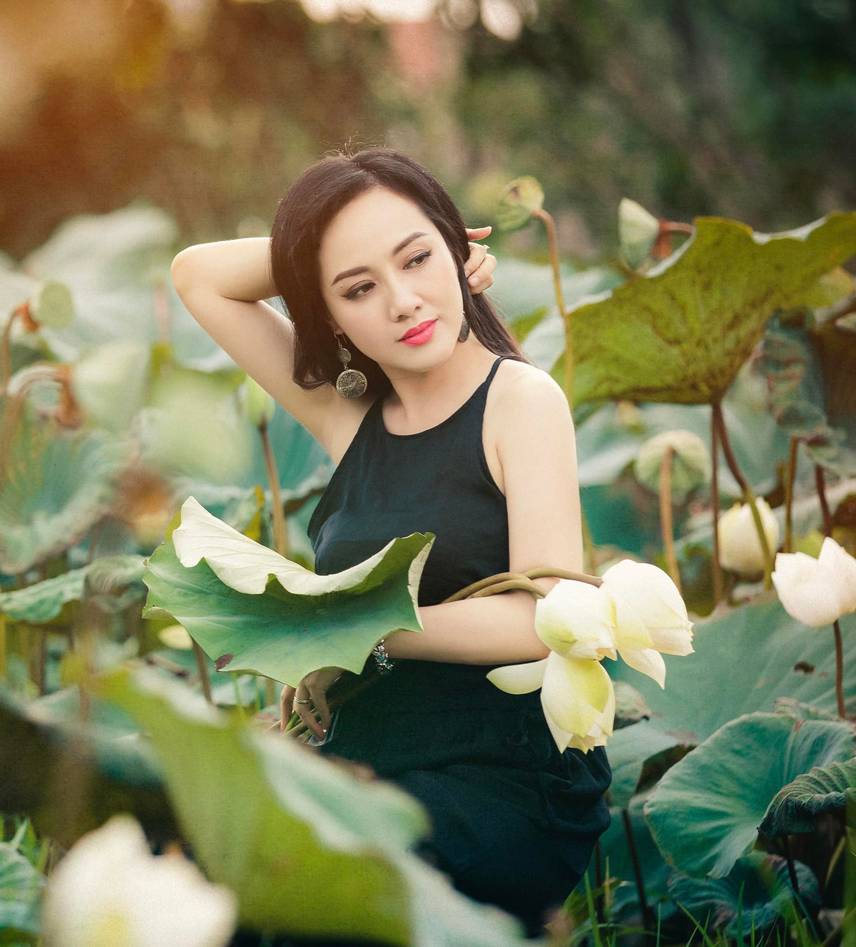 Trong bộ ảnh, BTV VTV được khen khi mặc áo yếm, đội nón lá chụp ảnh giữa đầm sen.