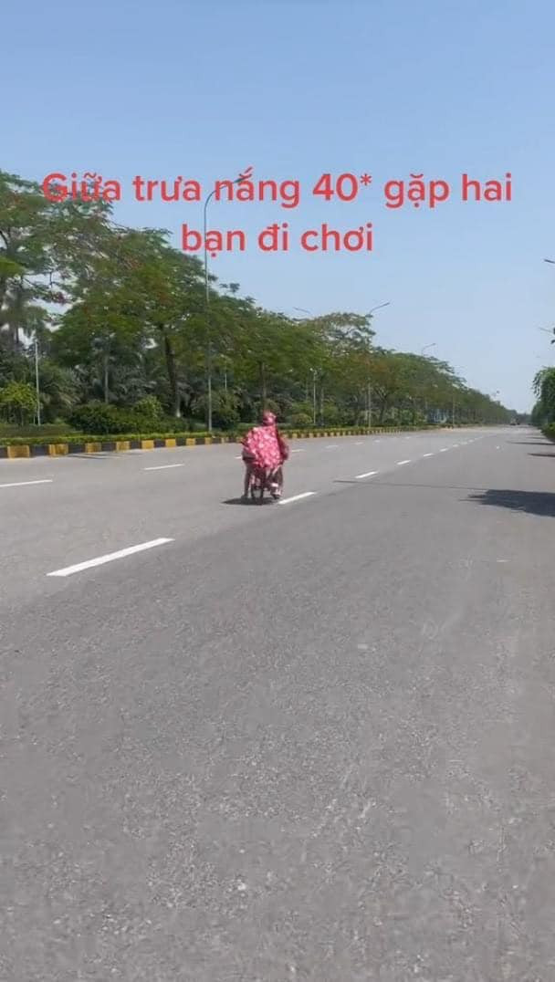 Theo clip ghi lại, thời điểm Hà Nội nắng nóng 40 độ, đường phố gần như không có ai đi lại thì xuất hiện hai em nhỏ đi xe đạp màu hồng, trùm áo mưa hồng và thong thả đạp xe giữa lòng đường.