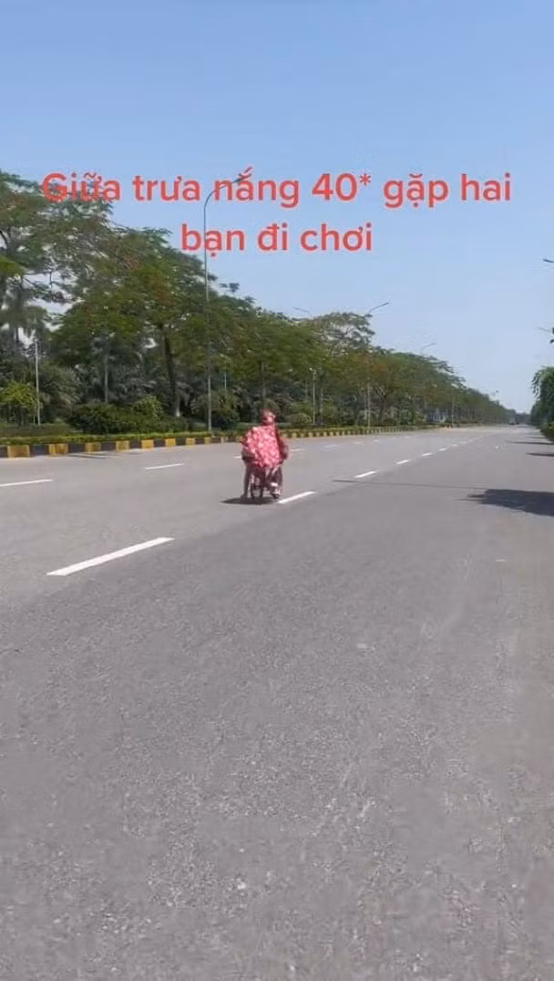 Theo clip ghi lại, thời điểm Hà Nội nắng nóng 40 độ, đường phố gần như không có ai đi lại thì xuất hiện hai em nhỏ đi xe đạp màu hồng, trùm áo mưa hồng và thong thả đạp xe giữa lòng đường.