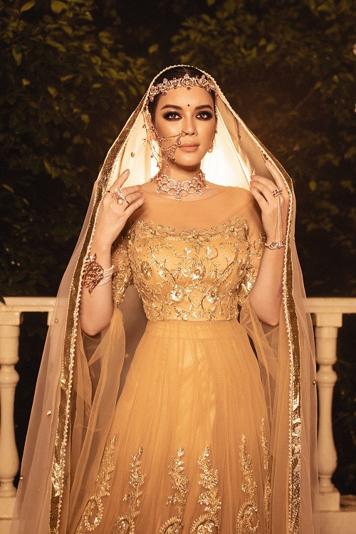 Lý Nhã Kỳ diện váy haute couture, các sợi chỉ vàng được nhà thiết kế Ấn kết thành những cánh hoa xinh xắn, sử dụng kỹ thuật dập vân nổi họa tiết 3D bằng vàng 18k vô cùng sang trọng.