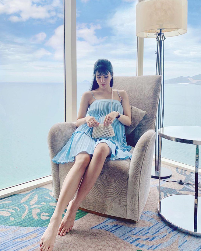 Cô được khen dịu dàng khi kết hợp khéo léo túi nạm ngọc trai với đầm xếp li sắc xanh thanh mát.