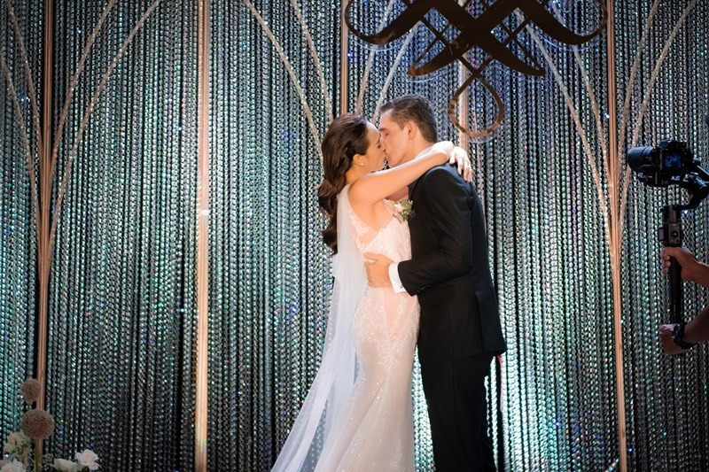 Cả hai cùng đưa tay về phía nhau nắm chặt, trao nhau nụ hôn ngọt ngào trước sự chứng kiến của bạn bè, người thân.