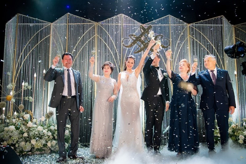 Hai bên gia đình cùng cô dâu chú rể uống mừng ngày hạnh phúc. Phương Mai cho biết, gia đình chồng và nhiều bạn bè đến dự hôn lễ là người nước ngoài, do đó cô muốn có một tiệc cưới thật giản dị, vui vẻ, không nặng về phần nghi lễ của người Việt.