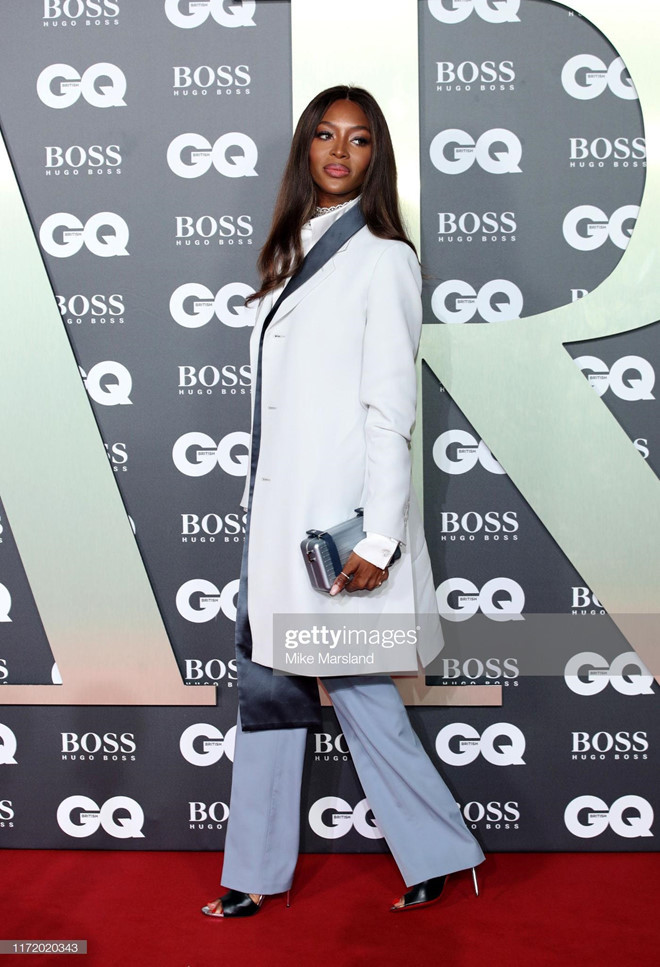 Naomi Campbell phối sơ mi lụa với blazer dáng dài, quần ống đứng.