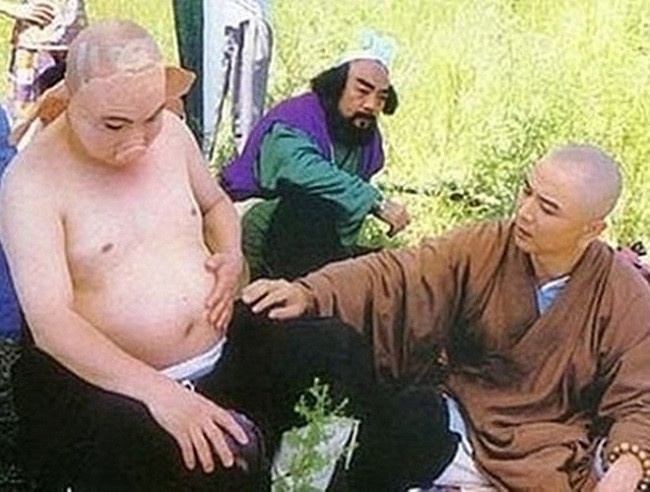 Đường Tăng (Từ Thiếu Hoa) xoa chiếc bụng giả của Trư Bát Giới khi cả hai đang hóa trang.