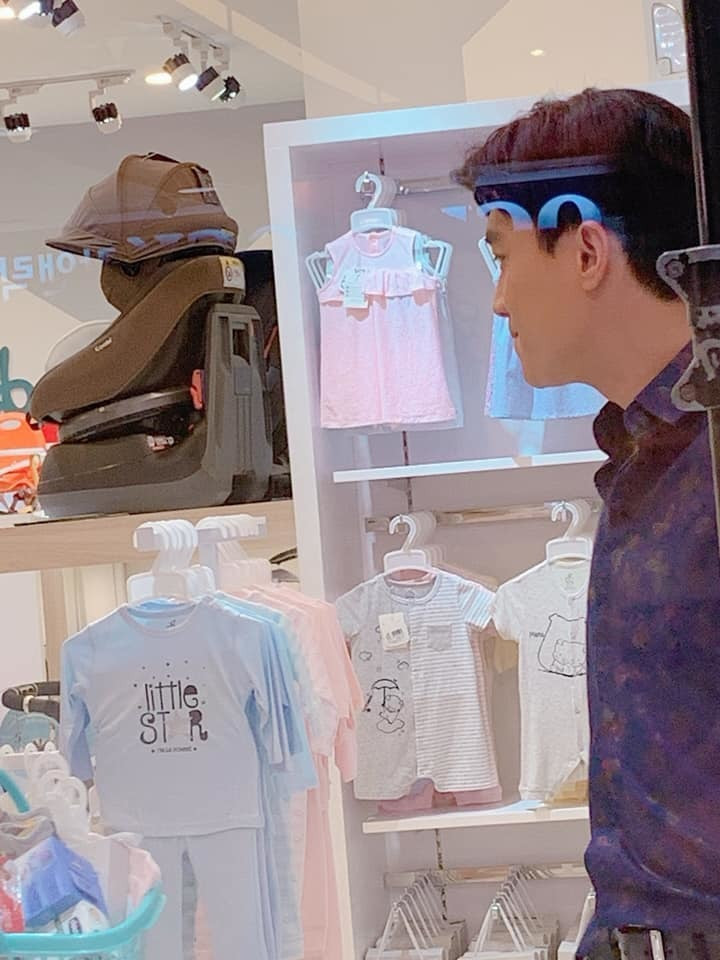 Ông bố bất đắc dĩ - Vũ (Quốc Trường) trong một cửa hàng bán đồ cho trẻ sơ sinh.