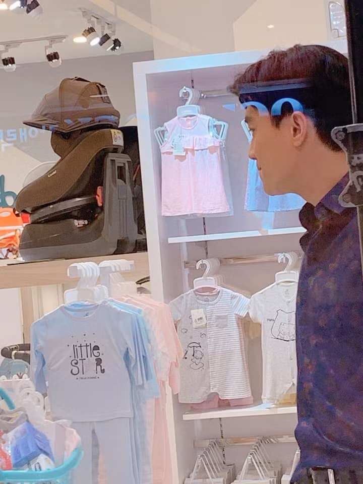 Ông bố bất đắc dĩ - Vũ (Quốc Trường) trong một cửa hàng bán đồ cho trẻ sơ sinh.